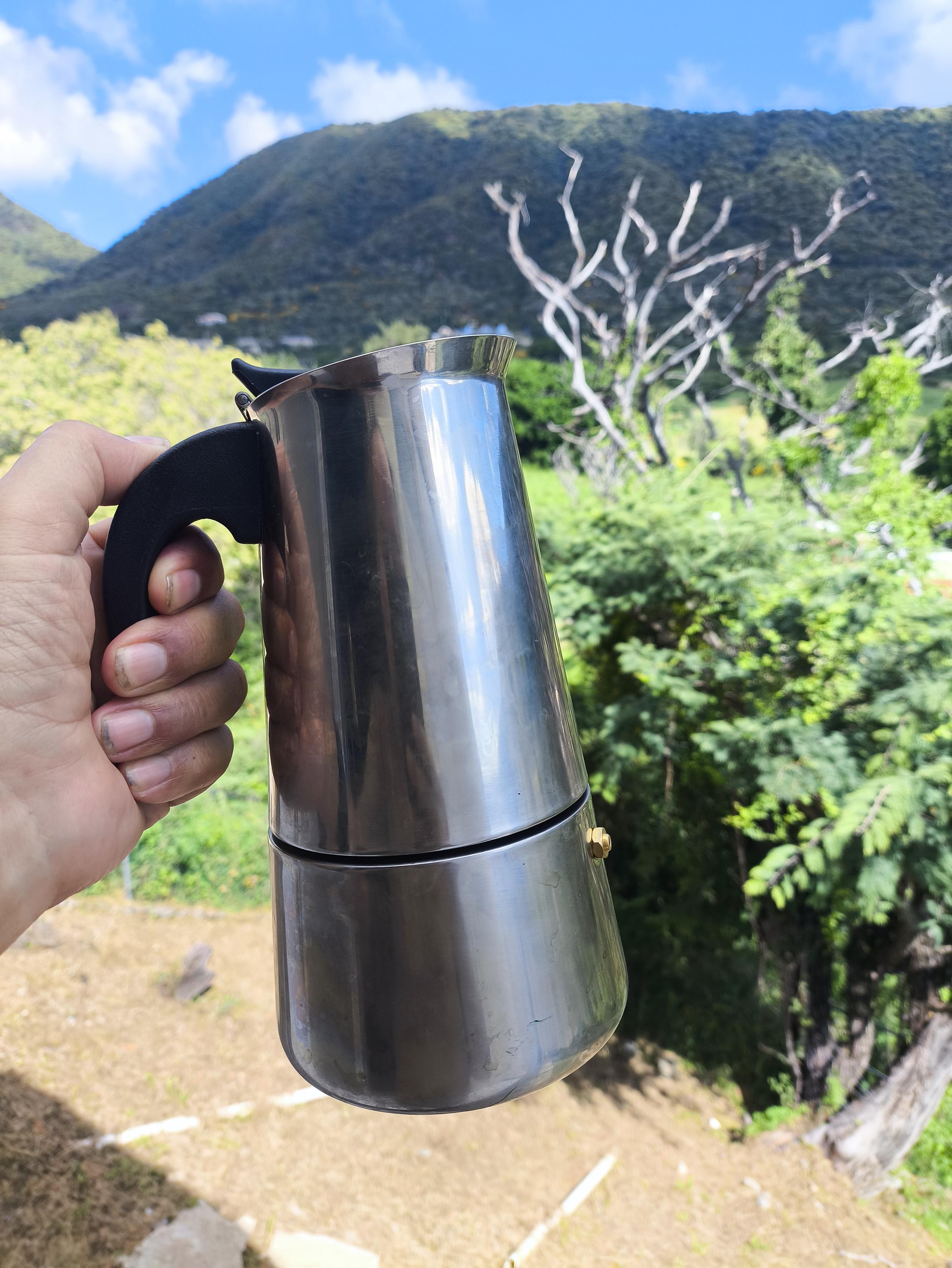 Cafetera italiana, fondo de montañas.